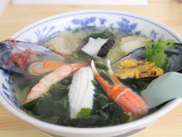 貝やホタテ、エビ、わかめなど色々な種類の海鮮が盛り付けられている海鮮ラーメンの写真