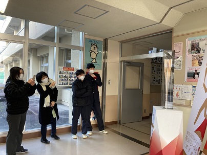 久慈工業高校へ出張展示された聖火リレートーチを生徒たちが見たり携帯で撮影している様子の写真