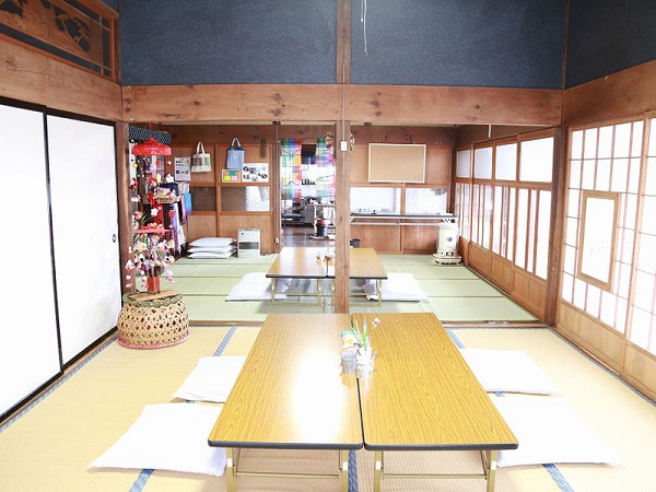 二間続きの和室に、4人ずつ座れるように長机が2台と座布団が置かれている室内写真