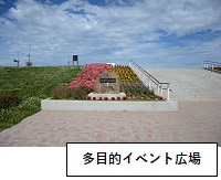 多目的イベント広場：左側にある花壇に沢山の花が植えられ、花壇右側に階段がある写真