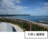 十府ヶ浦海岸：手前にコンクリートで出来たベンチがあり、フェンスの奥には海が見えている写真