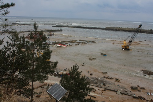 クレーン車1台が茶色く濁った海水の中にある野田港被害状況の写真