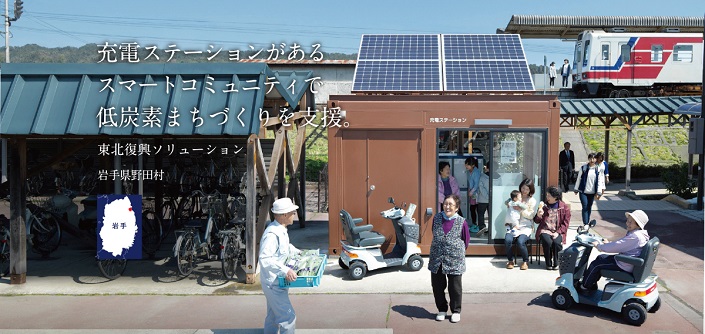 充電ステーションがあるスマートコミュニティで低炭素まちづくりを支援。東北ソリューション岩手県野田村と書かれた、充電ステーションにいろいろな人たちが集まっている写真