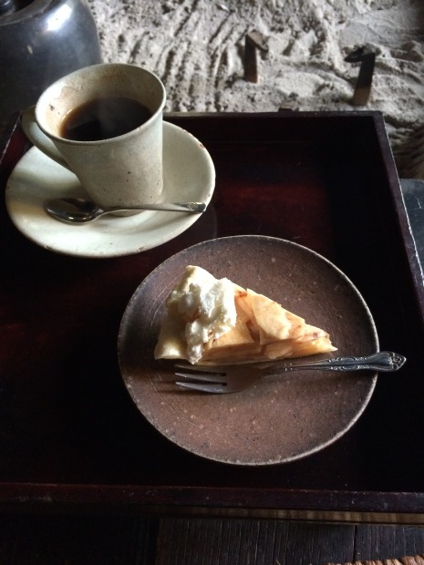 コヒーカップに入ったコヒーと丸いお皿にのせられたケーキセットの写真