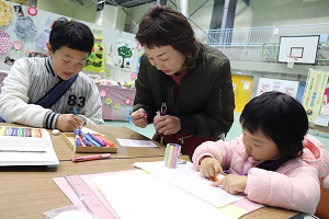 色鉛筆やマジックペンで絵をかいている親子の写真