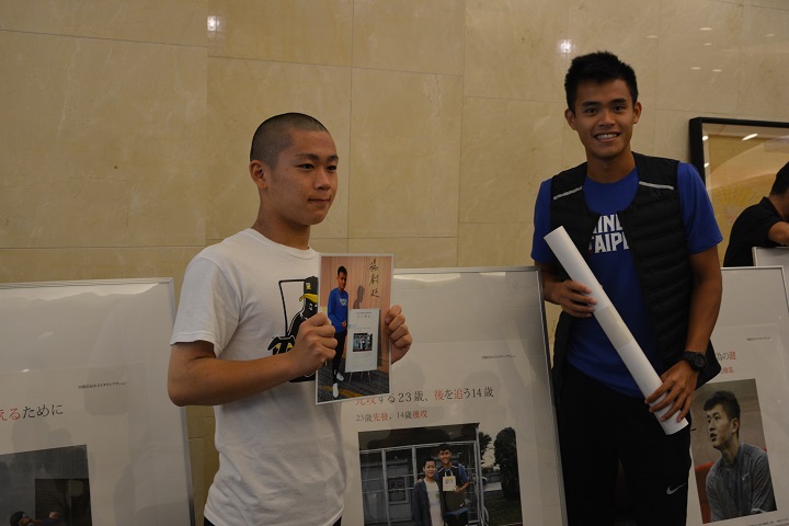 選手のポスターを持っている男子中学生と台湾陸上選手の男性の写真